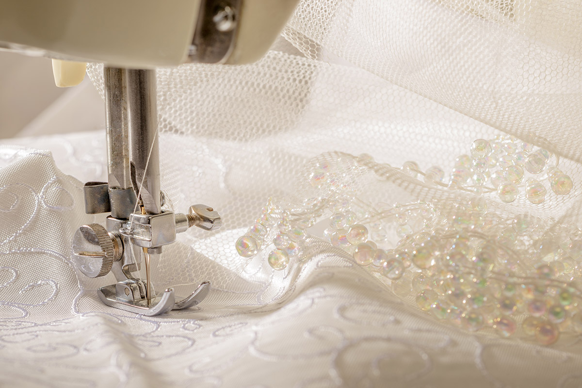 Ivory wedding dress fabric being sewn on vintage machine